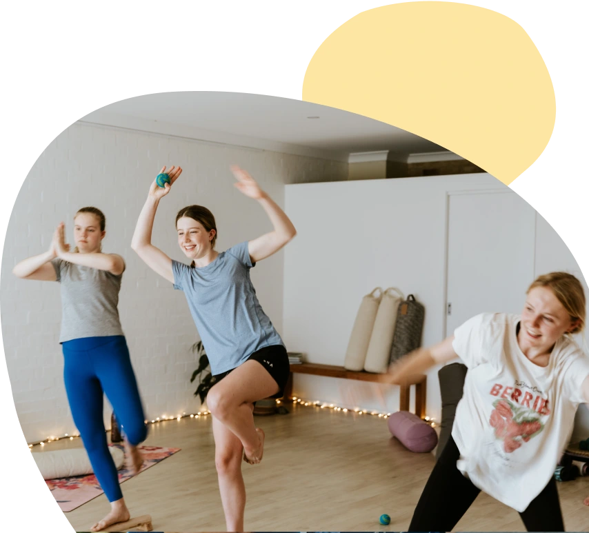 Three people doing yoga in a yoga studio.